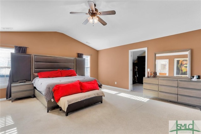 bedroom featuring a spacious closet, ceiling fan, light carpet, and lofted ceiling