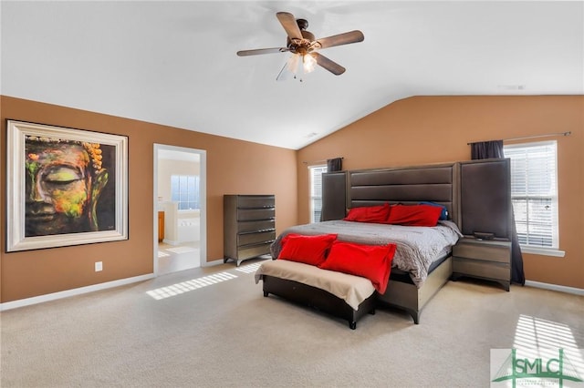 carpeted bedroom with vaulted ceiling, ensuite bath, and ceiling fan