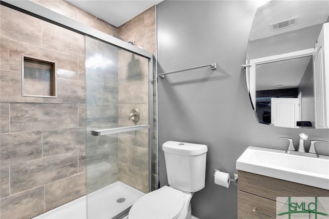 bathroom featuring vanity, an enclosed shower, and toilet