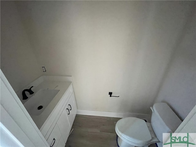 bathroom with vanity, hardwood / wood-style flooring, and toilet