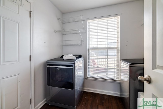 laundry room featuring washer and clothes dryer, dark hardwood / wood-style floors, and a wealth of natural light