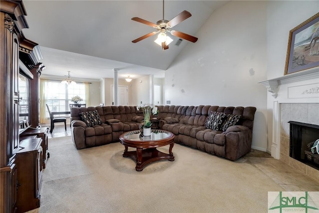 carpeted living room featuring a tile fireplace, high vaulted ceiling, ceiling fan, and ornate columns