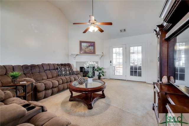 living room featuring a premium fireplace, ceiling fan, light colored carpet, and vaulted ceiling