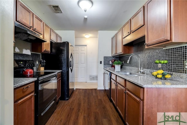 kitchen with black appliances, sink, dark hardwood / wood-style floors, tasteful backsplash, and light stone counters