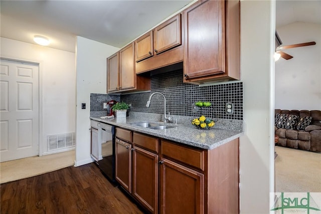 kitchen featuring decorative backsplash, dark hardwood / wood-style flooring, ceiling fan, sink, and black dishwasher