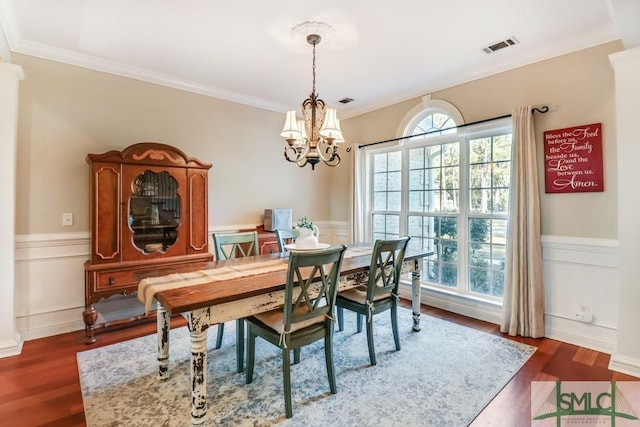 dining space featuring an inviting chandelier, dark wood-type flooring, and ornamental molding