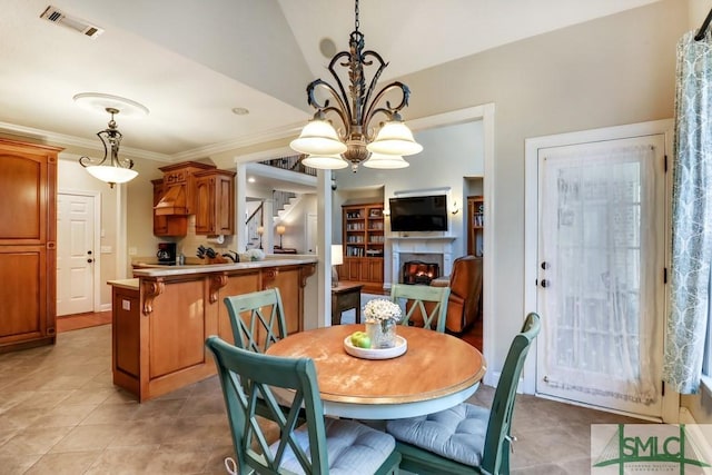 tiled dining area with lofted ceiling, crown molding, and a chandelier