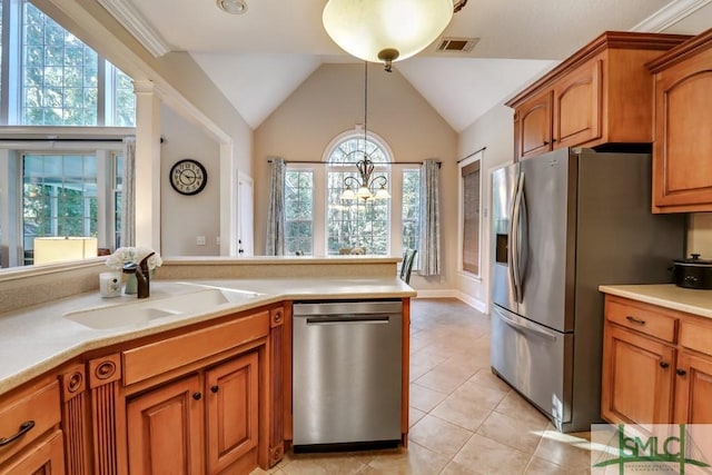 kitchen with light tile patterned flooring, sink, decorative light fixtures, vaulted ceiling, and stainless steel appliances