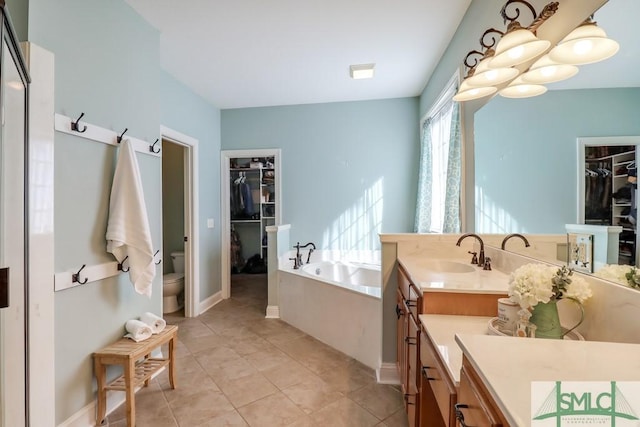 bathroom with vanity, a bathtub, tile patterned floors, and toilet