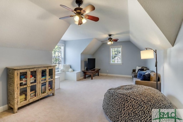 interior space featuring multiple windows, lofted ceiling, and ceiling fan