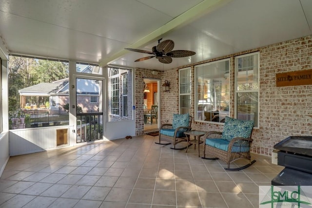 unfurnished sunroom featuring beamed ceiling and ceiling fan