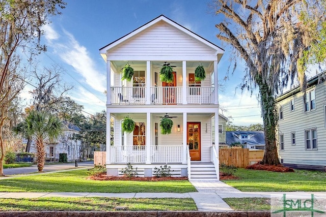 view of front of home with ceiling fan, a porch, and a front lawn