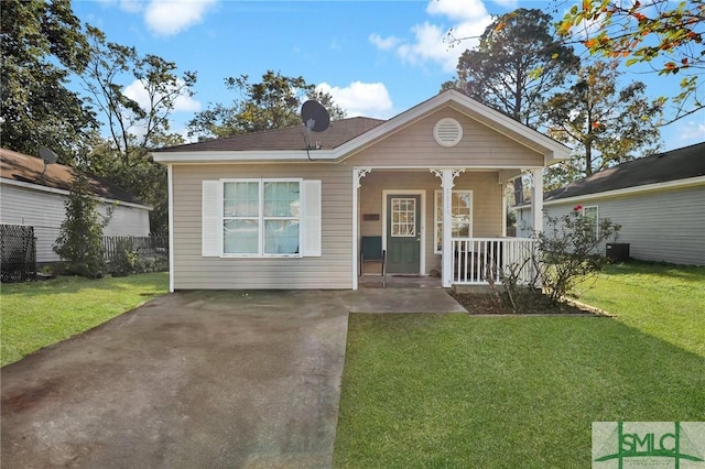 bungalow with central air condition unit, covered porch, and a front yard