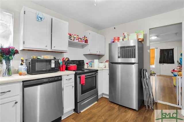 kitchen featuring stainless steel appliances, white cabinetry, and dark hardwood / wood-style floors