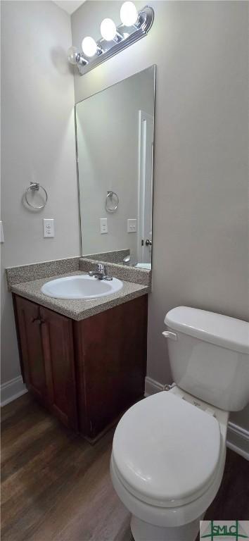 bathroom with vanity, wood-type flooring, and toilet