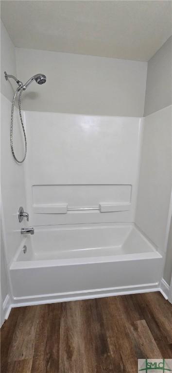 bathroom featuring hardwood / wood-style flooring and bathtub / shower combination