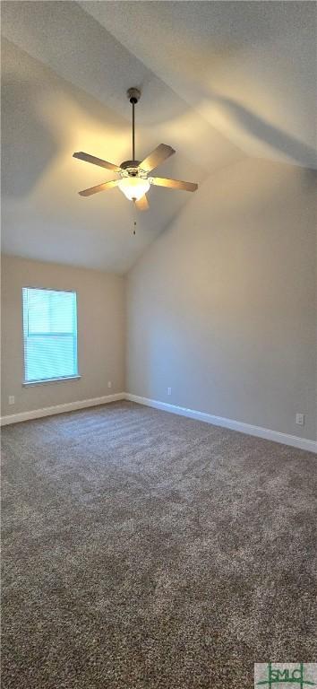 carpeted spare room featuring a textured ceiling, ceiling fan, and vaulted ceiling