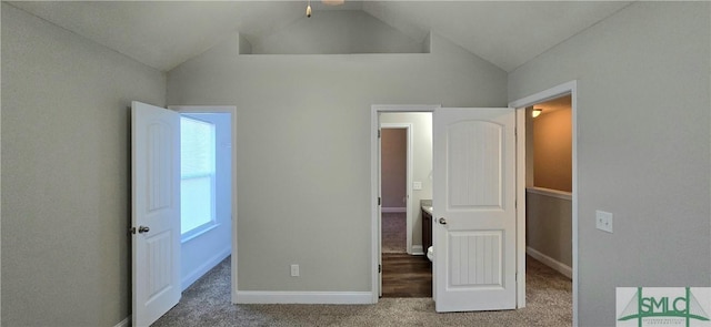 unfurnished bedroom with carpet and vaulted ceiling