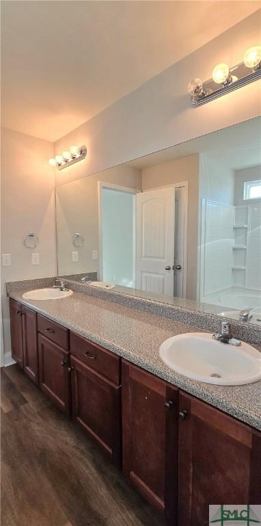 bathroom featuring a shower, wood-type flooring, and vanity