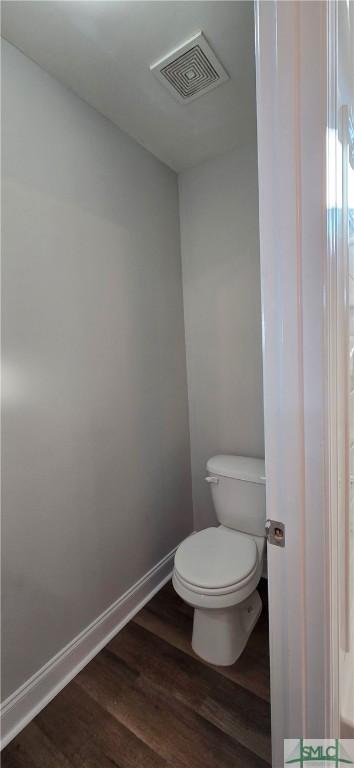 bathroom with toilet and hardwood / wood-style flooring