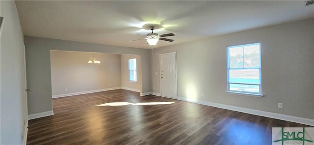 unfurnished room with dark hardwood / wood-style floors and ceiling fan with notable chandelier