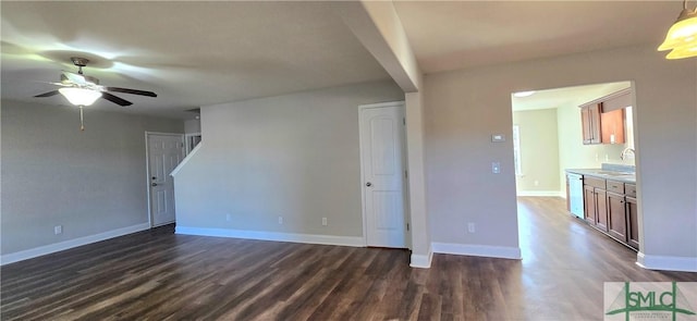 unfurnished living room with dark hardwood / wood-style floors, ceiling fan, and sink