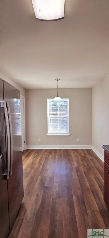 unfurnished dining area with dark wood-type flooring