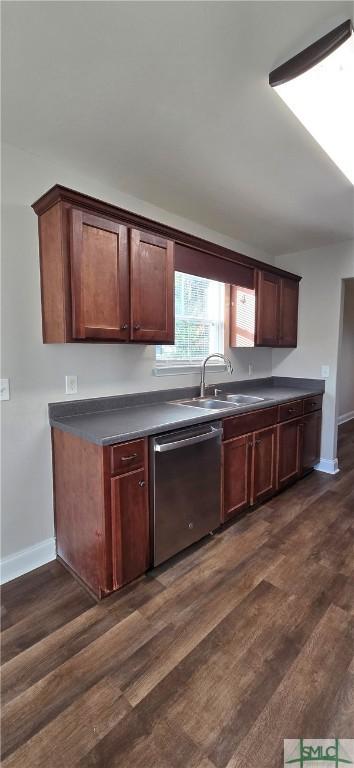 kitchen with dark hardwood / wood-style flooring, stainless steel dishwasher, and sink