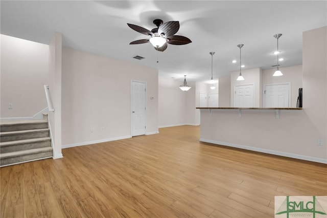 unfurnished living room with ceiling fan and light hardwood / wood-style floors