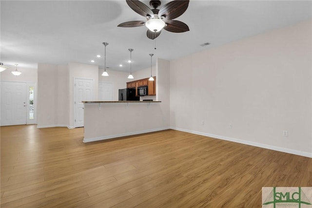 unfurnished living room featuring light hardwood / wood-style floors and ceiling fan