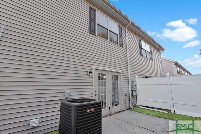 rear view of property featuring a patio, central AC unit, and french doors