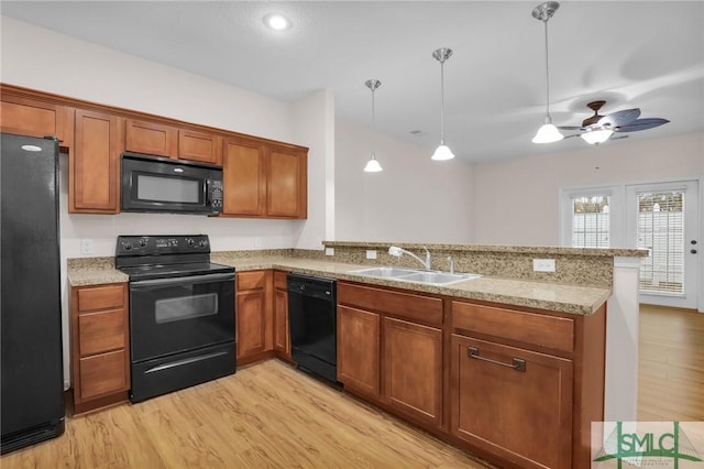 kitchen with sink, black appliances, hanging light fixtures, and kitchen peninsula