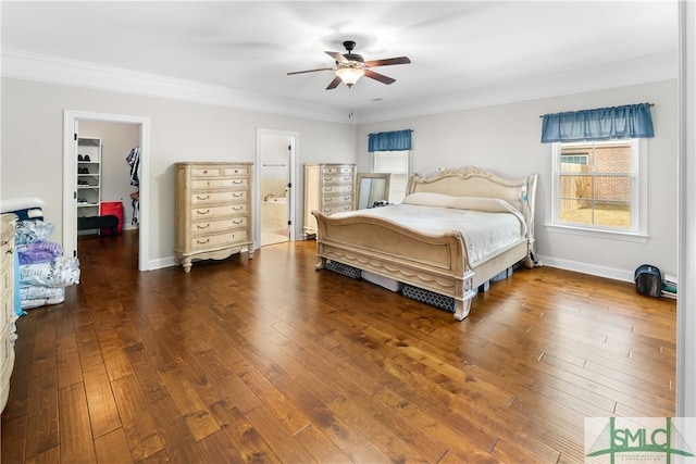 bedroom featuring a spacious closet, ensuite bath, dark wood-type flooring, and ceiling fan