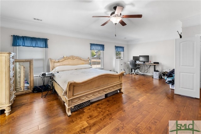 bedroom featuring dark hardwood / wood-style flooring, ceiling fan, and crown molding