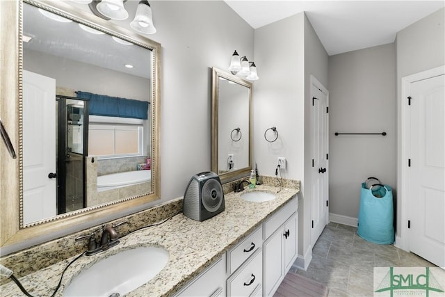 bathroom with tile patterned floors, a washtub, and vanity