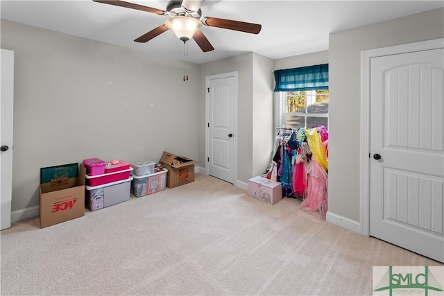 recreation room featuring light carpet and ceiling fan