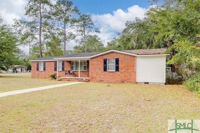 ranch-style home featuring covered porch and a front lawn