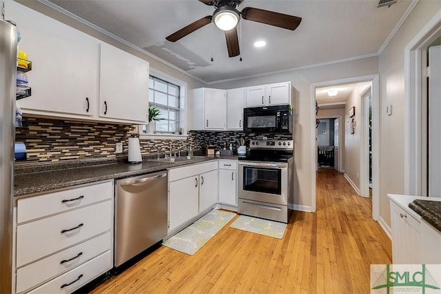 kitchen featuring appliances with stainless steel finishes, light wood-type flooring, crown molding, sink, and white cabinets