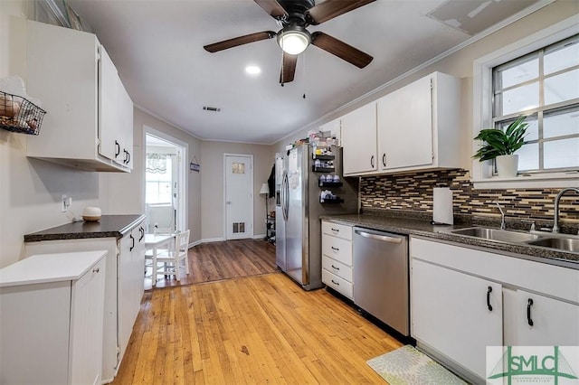 kitchen featuring white cabinetry, sink, appliances with stainless steel finishes, and light hardwood / wood-style flooring