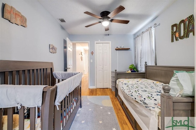 bedroom featuring ceiling fan, light wood-type flooring, and a closet