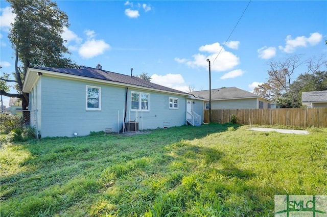 back of house featuring a lawn and central AC