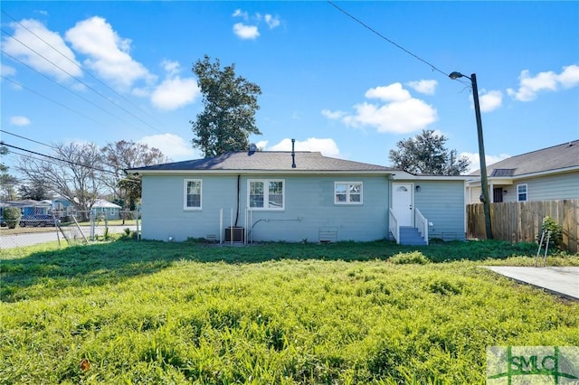 rear view of house featuring a lawn