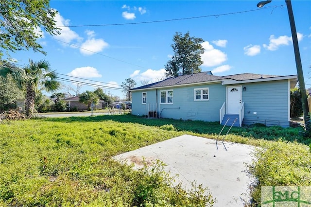 back of house with a patio area and a yard