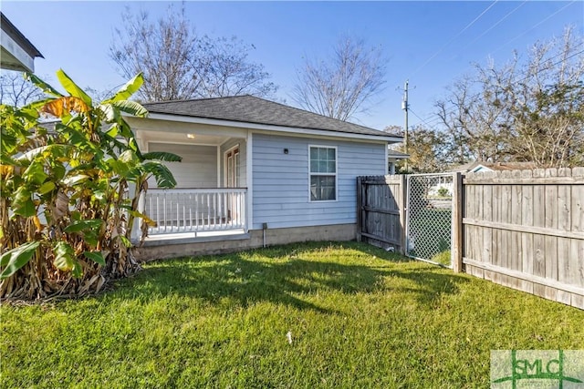 rear view of property featuring covered porch and a lawn