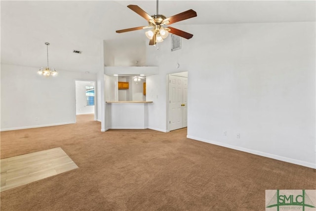 unfurnished living room with carpet flooring, high vaulted ceiling, and ceiling fan with notable chandelier