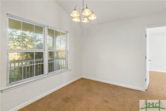 empty room with lofted ceiling, carpet floors, and an inviting chandelier