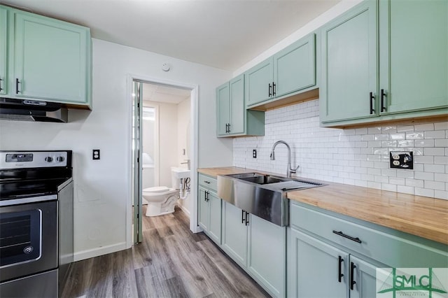 kitchen featuring light wood-type flooring, sink, exhaust hood, butcher block counters, and stainless steel electric range