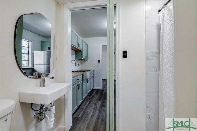 bathroom with tasteful backsplash, sink, hardwood / wood-style floors, and toilet