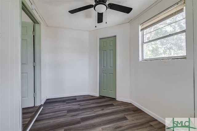 spare room featuring a textured ceiling, ceiling fan, and dark wood-type flooring