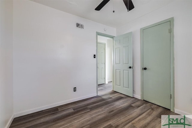 unfurnished bedroom featuring dark hardwood / wood-style floors and ceiling fan